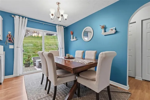 a view of a dining room with furniture a chandelier and wooden floor