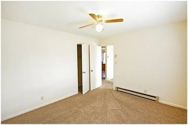 a view of a livingroom with a ceiling fan and wooden floor