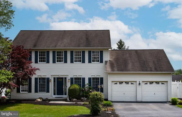 front view of a house with a stove and a large tree