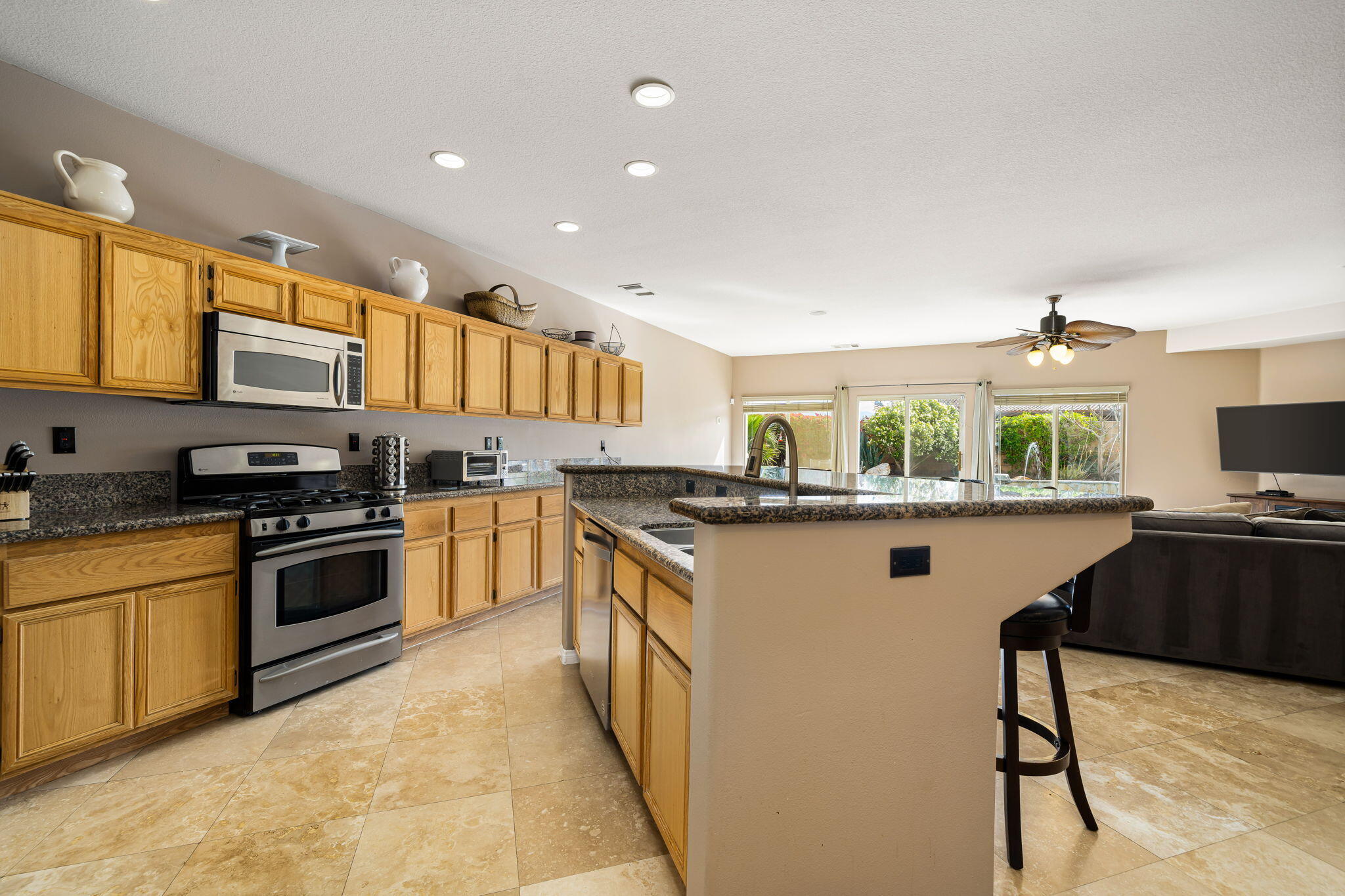 41222 Mackenzie Lane Indio, CA 92203 - Photo 12 of 27 a kitchen with stainless steel appliances granite countertop a stove a sink and a refrigerator