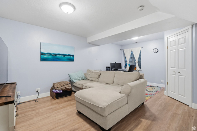 1099 South 950 East, Unit 17 Provo, UT 84606 - Photo 14 of 23 Living area featuring wood-finish flooring, light blue walls, recessed lighting, and white bi-fold closet doors