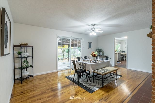 a dining room with furniture a rug a chandelier and wooden floor