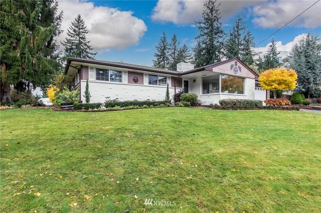a view of a house with a big yard and large trees