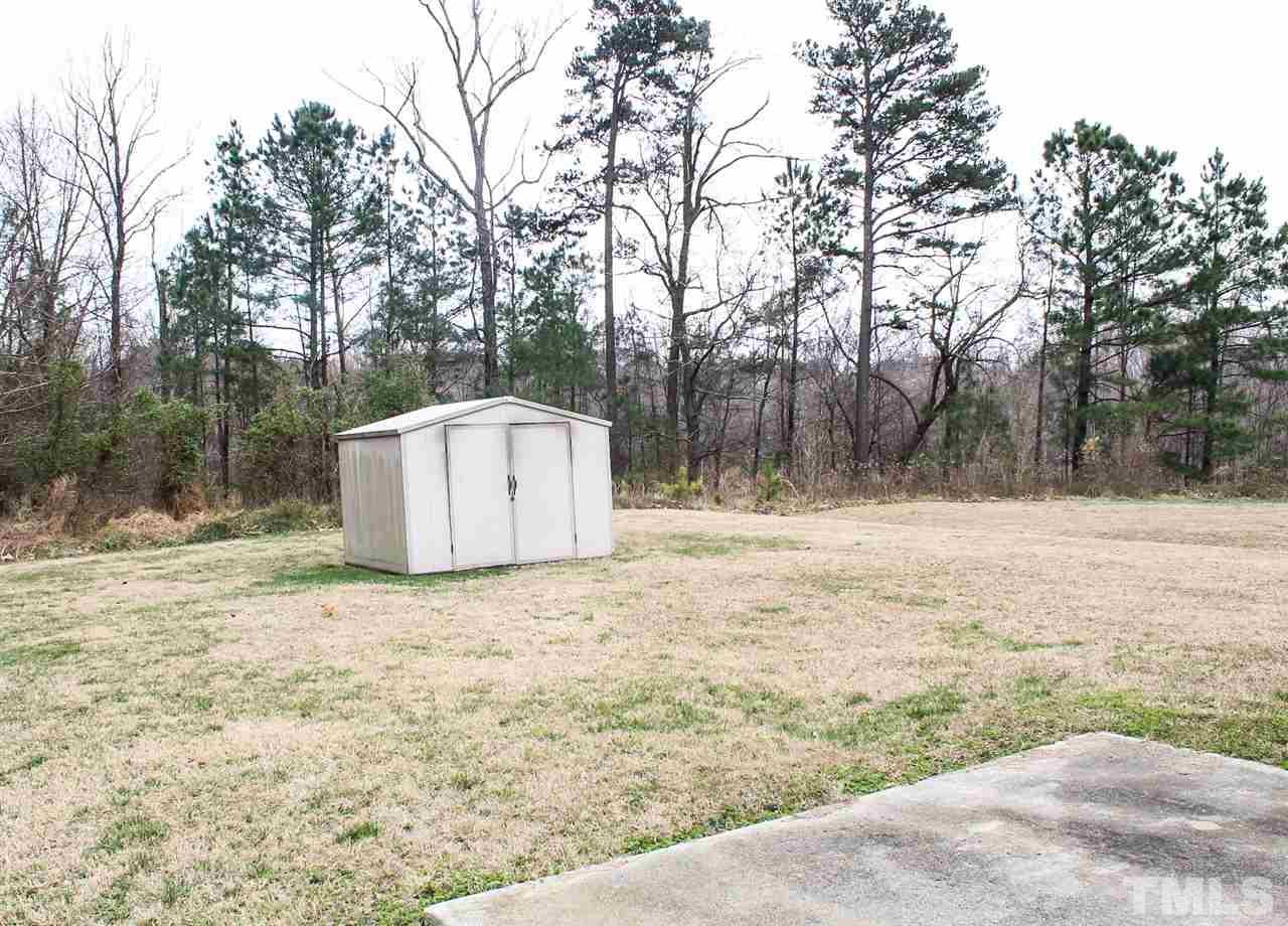 2912 Tuckland Drive Raleigh, NC 27610 - Photo 23 of 25 a backyard of a house with large trees and covered with wooden fence