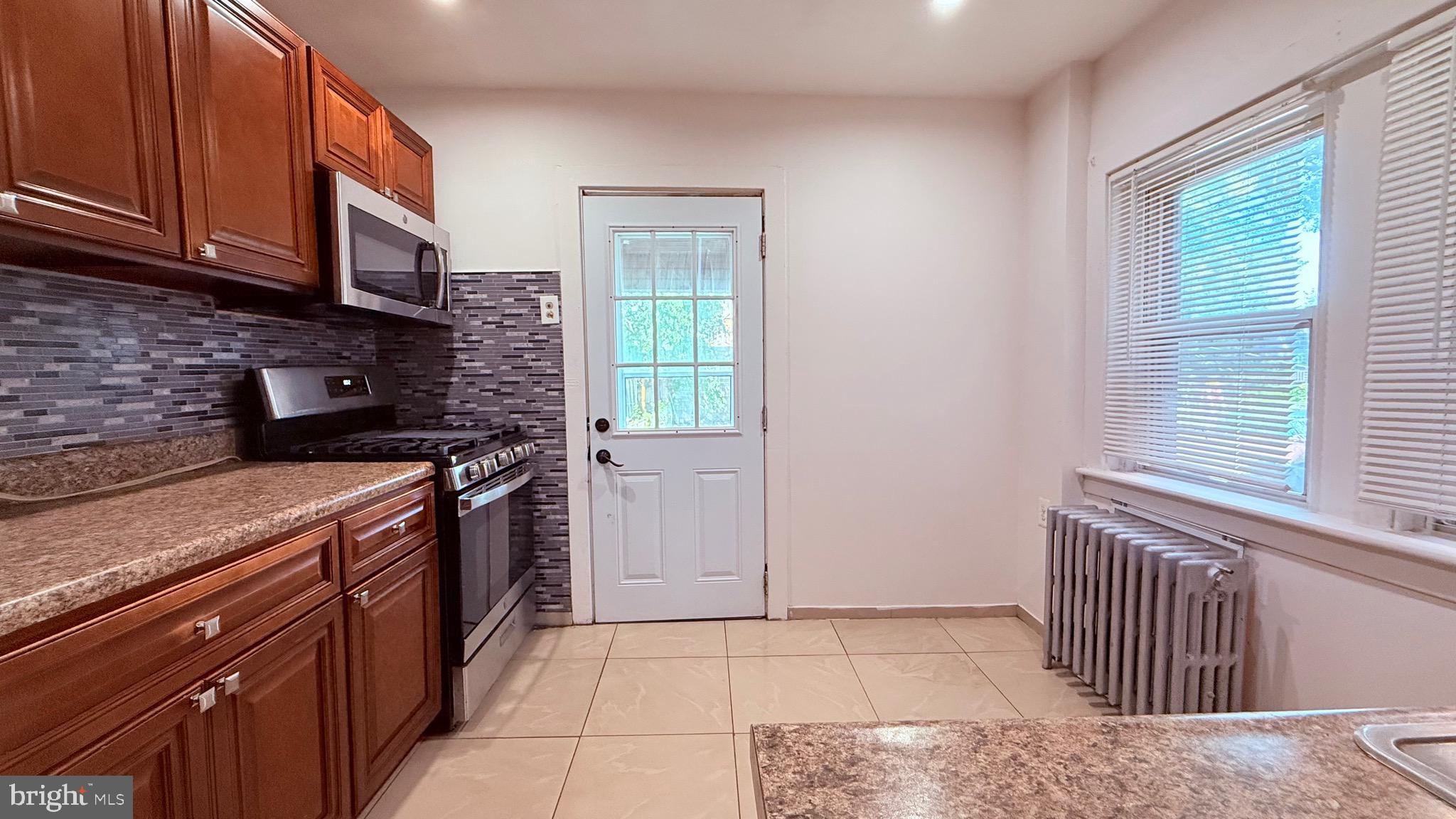 6424 Bingham Street Philadelphia, PA 19111 - Photo 9 of 32 a kitchen with stainless steel appliances granite countertop a stove a sink and a microwave