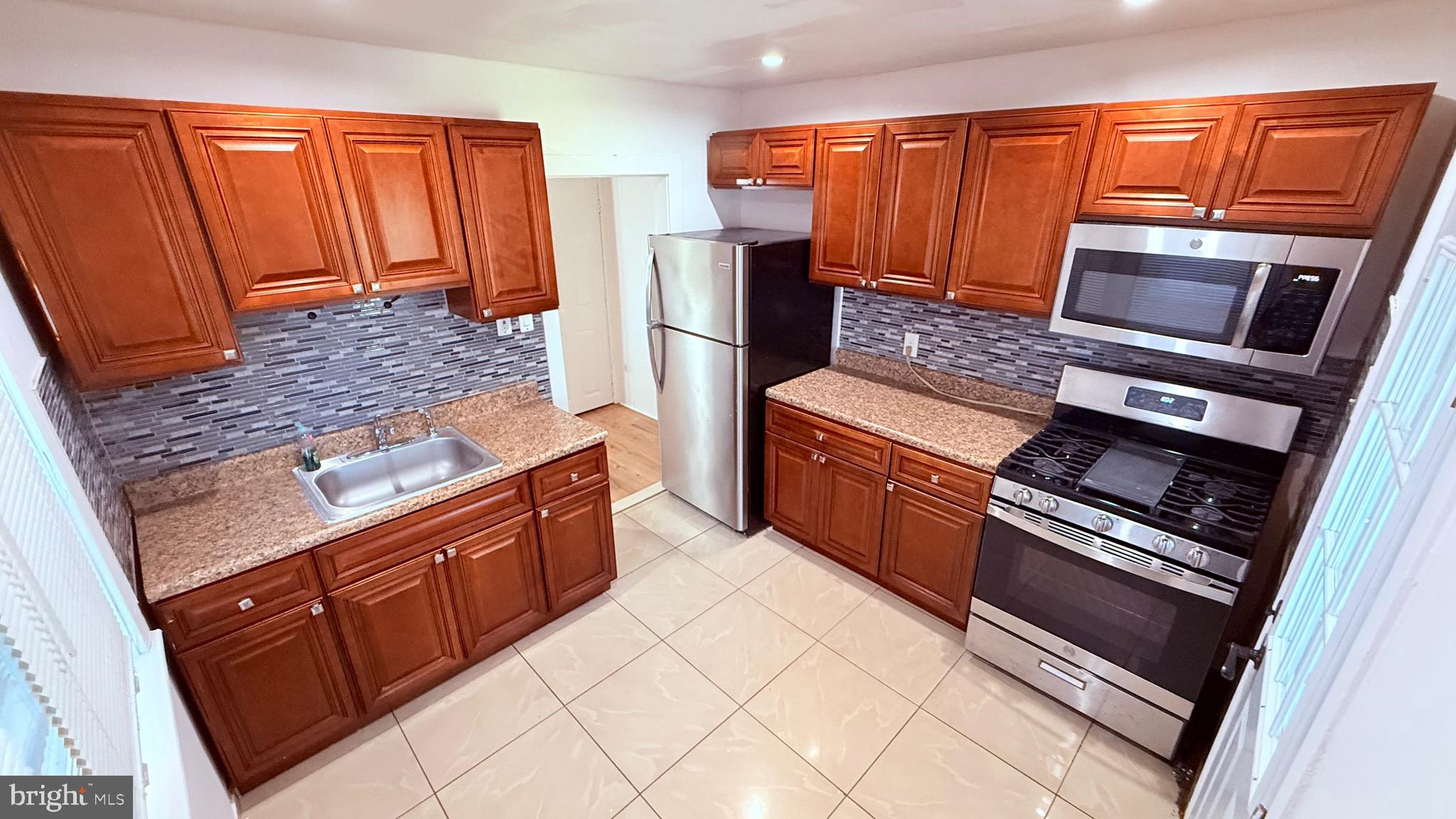 6424 Bingham Street Philadelphia, PA 19111 - Photo 10 of 32 a kitchen with stainless steel appliances granite countertop a refrigerator oven a sink and dishwasher