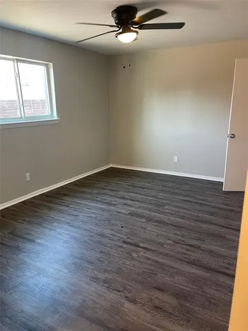 an empty room with wooden floor and entrance