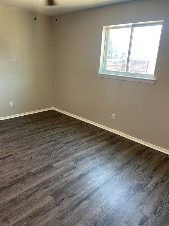 5526 Reiger Avenue, Unit 104 Dallas, TX 75214 - Photo 14 of 14 a view of an empty room with wooden floor and a window