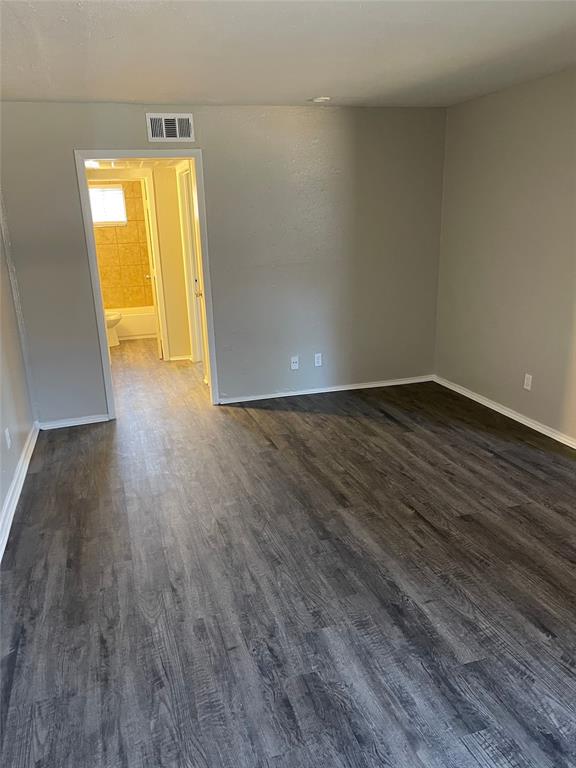5526 Reiger Avenue, Unit 104 Dallas, TX 75214 - Photo 4 of 14 a view of an empty room with wooden floor and a window