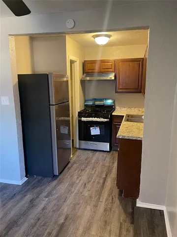 a kitchen with stainless steel appliances granite countertop a refrigerator a stove and a sink