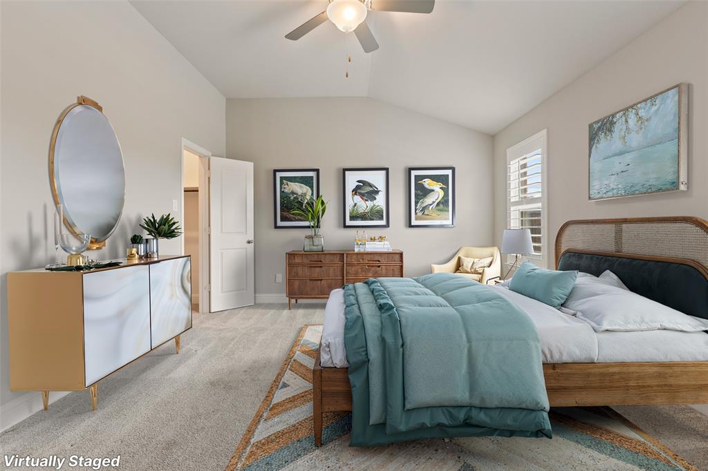 6909 Danridge Road Rowlett, TX 75089 - Photo 11 of 29 a bedroom with a large bed and a chandelier