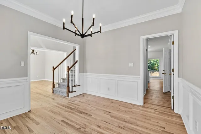 a view of an empty room with wooden floor fireplace and a window