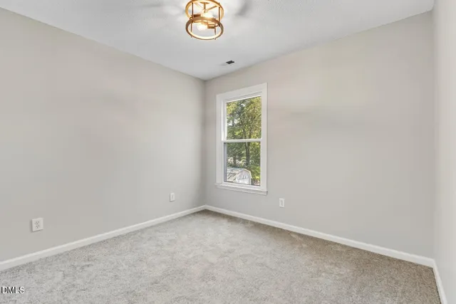 a bedroom with a bed a lamp and a window