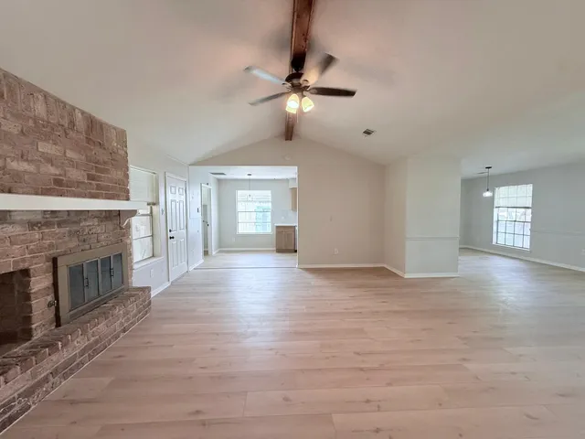 a view of an empty room with a fireplace and a window