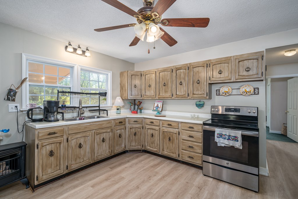1813 John Smith Road East Blairsville, GA 30512 - Photo 4 of 41 a kitchen with stainless steel appliances a stove sink and cabinets