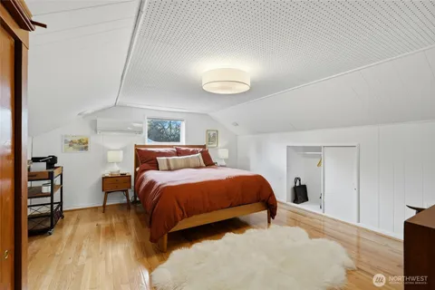 a bedroom with a bed and a flat tv screen on dresser