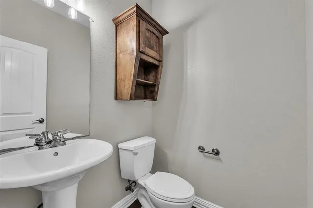 a bathroom with a sink toilet and a mirror