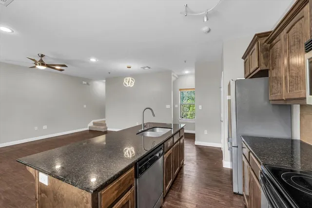 a kitchen with stainless steel appliances granite countertop a stove microwave and refrigerator