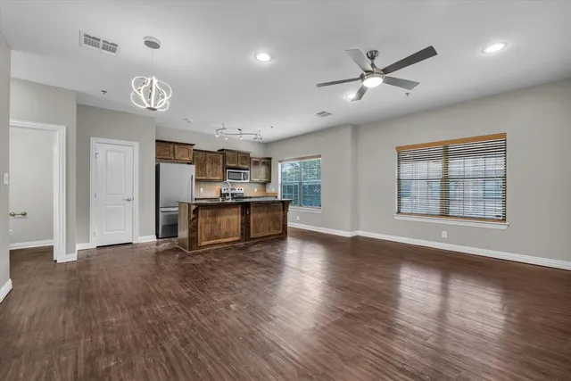 a kitchen with stainless steel appliances granite countertop a sink a stove and a refrigerator