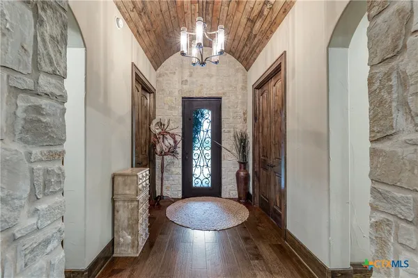 a bathroom with a granite countertop toilet a mirror and shower curtain
