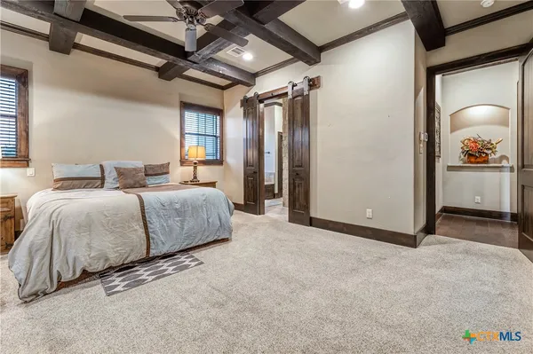a spacious bedroom with a bed and a chandelier