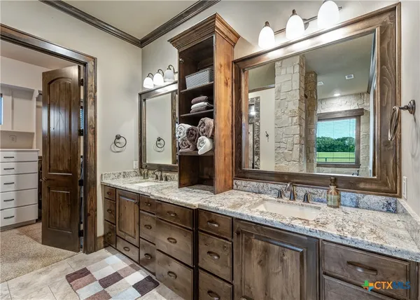 a bathroom with a granite countertop double vanity sink and a mirror
