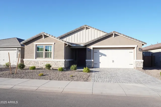 a front view of a house with a garden and yard