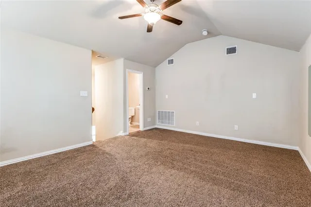 an empty room with ceiling fan and window