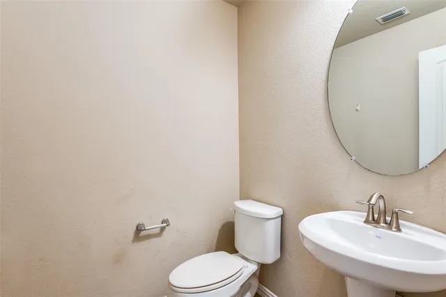 a white toilet sitting next to a bathroom sink