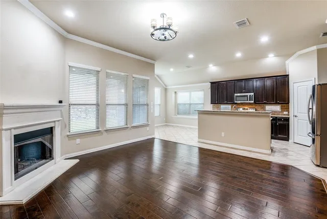 a view of a kitchen with a stove wooden cabinets and entryway