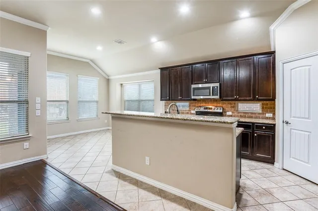 a kitchen with stainless steel appliances granite countertop a refrigerator and a stove top oven