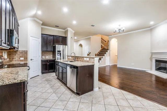 a kitchen with stainless steel appliances kitchen island granite countertop a stove a sink and a refrigerator