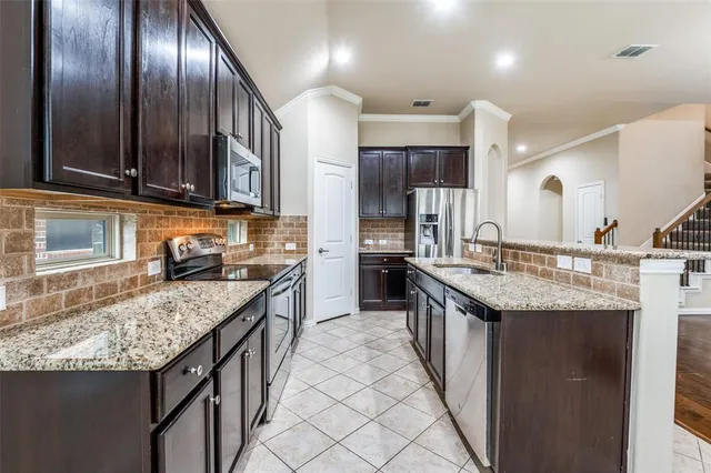 a kitchen with stainless steel appliances granite countertop granite counter tops a sink a stove and cabinets