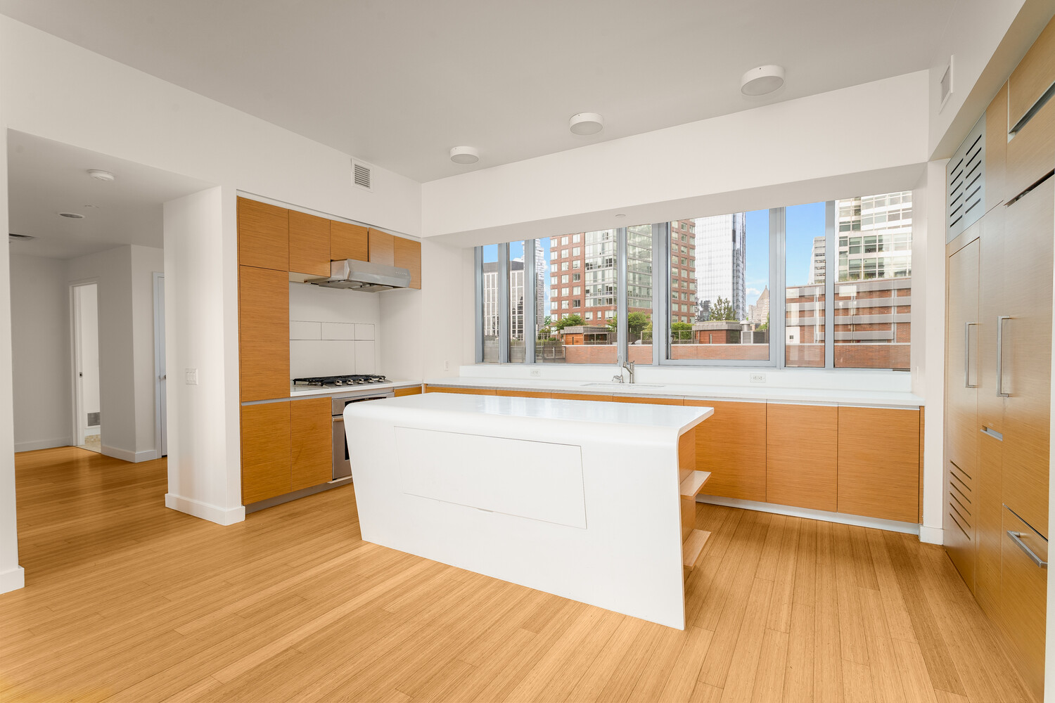 2 River Terrace, Unit 15T Manhattan, NY 10282 - Photo 7 of 22 a living room with a large window wooden floor and a kitchen counter space