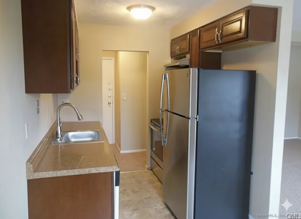 a kitchen with stainless steel appliances granite countertop a refrigerator and a sink