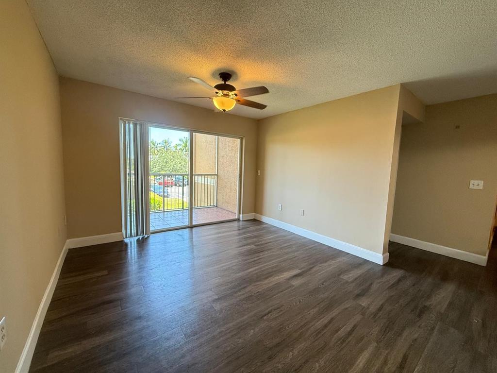 3779 Northwest Mediterranean Lane, Unit 207 Jensen Beach, FL 34957 - Photo 13 of 20 wooden floor in an empty room with a window