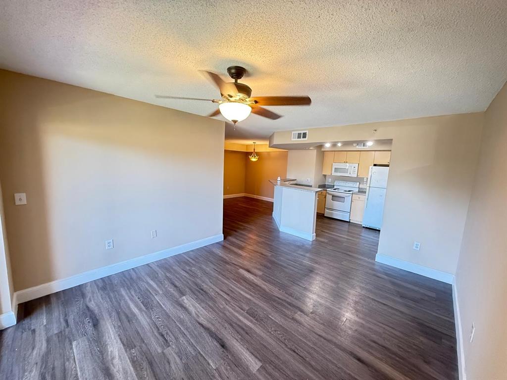 3779 Northwest Mediterranean Lane, Unit 207 Jensen Beach, FL 34957 - Photo 14 of 20 a view of a room with wooden floor a ceiling fan and window