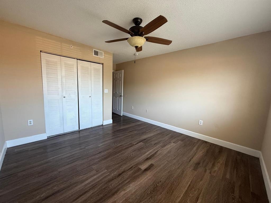 3779 Northwest Mediterranean Lane, Unit 207 Jensen Beach, FL 34957 - Photo 16 of 20 an empty room with wooden floor and ceiling fan