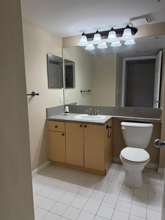 3779 Northwest Mediterranean Lane, Unit 207 Jensen Beach, FL 34957 - Photo 17 of 20 a bathroom with a toilet sink and mirror
