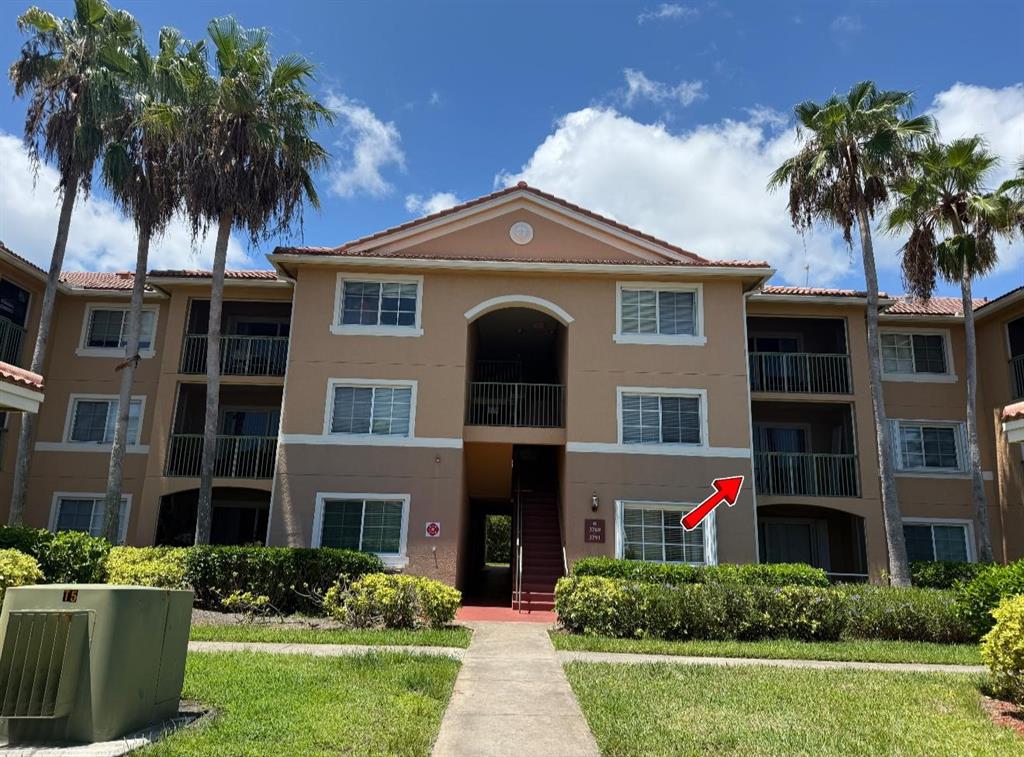 3779 Northwest Mediterranean Lane, Unit 207 Jensen Beach, FL 34957 - Photo 20 of 20 a front view of a house with a garden and plants