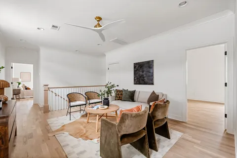 an empty room with wooden floor & windows and a bathroom
