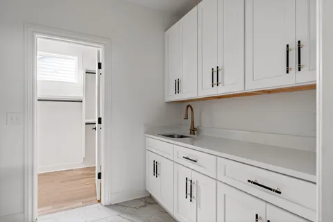 a view of a kitchen with white cabinets