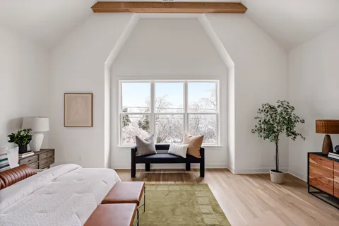 a bedroom with a bed and a large window