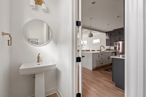 a kitchen with stainless steel appliances granite countertop a sink and cabinets with wooden floor