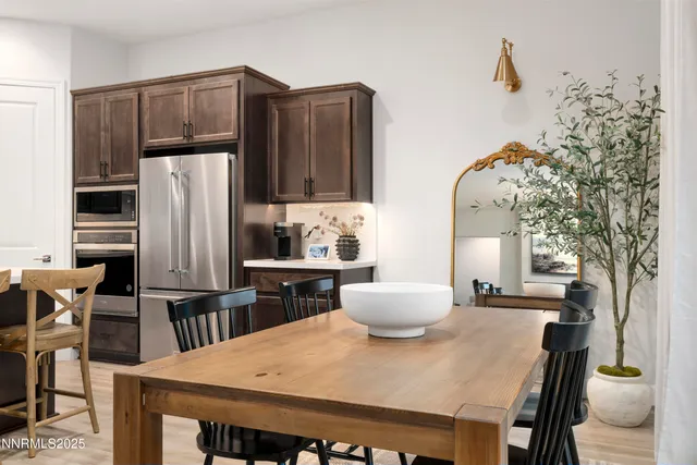a kitchen with stainless steel appliances a dining table and chairs