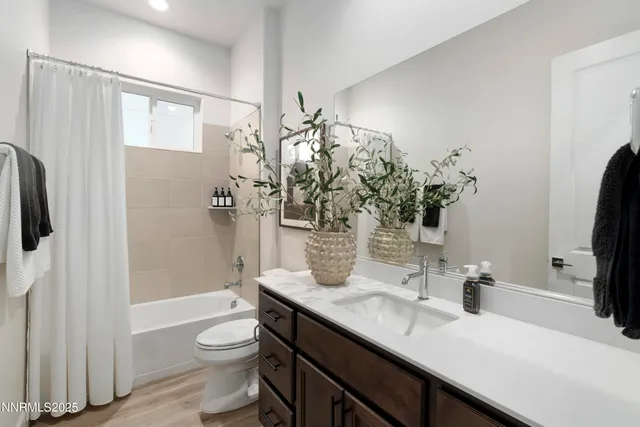 a bathroom with a granite countertop sink a toilet and shower
