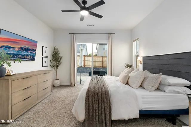 a bedroom with a large bed and a flat tv screen on dresser