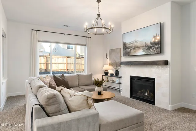 a living room with furniture a fireplace and a chandelier