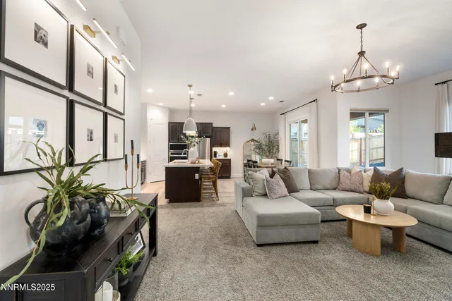 a living room with furniture a chandelier and a view of kitchen