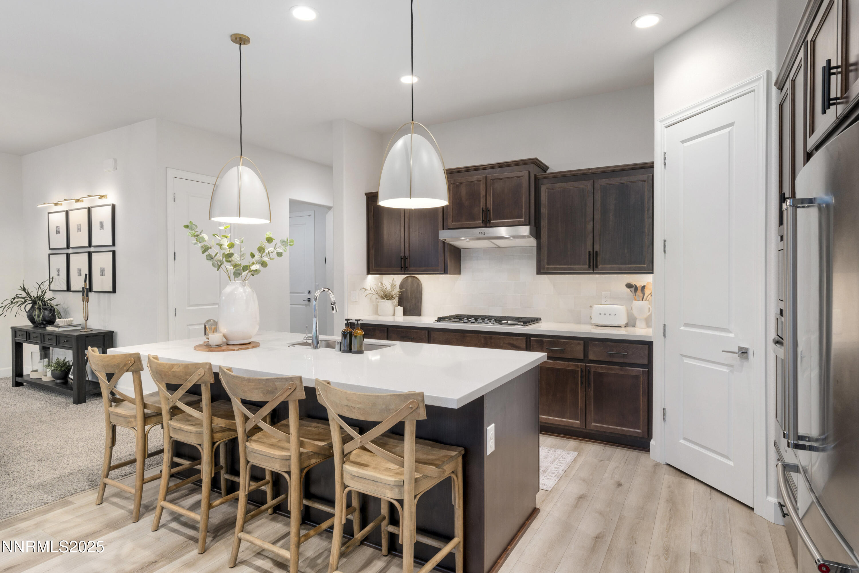 247 Starboard Drive Verdi, NV 89439 - Photo 9 of 41 a kitchen with stainless steel appliances kitchen island granite countertop a stove a sink a oven a dining table and chairs with wooden floor